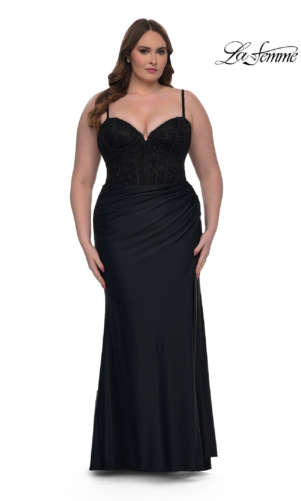 A woman models the Plus-Size Long Corset Prom Dress La Femme 32449, featuring a fitted black silhouette with a beaded bodice and thin straps, standing against a white background. The La Femme logo appears in the top right corner.
